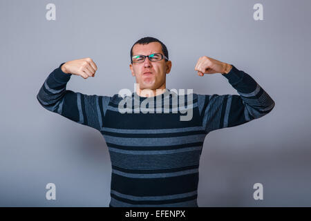 Maschio di aspetto europeo brunet alzò le mani e mostra th Foto Stock