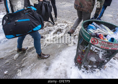 Pedoni slog attraverso pozzanghere di granite e neve in corrispondenza di incroci stradali con neve dam intasato Tempesta fognature nel quartiere di Chelsea di New York lunedì, 2 febbraio. 2015. I Newyorkesi sul modo di lavorare di fronte tutto il congelamento di pioggia, neve e pioggia normale come una tempesta passa attraverso la città. Si prevede che le temperature scendano al di e con maggiori precipitazioni la granita esistente e di stare in piedi acqua farà girare a pericolose ghiaccio. (© Richard B. Levine) Foto Stock