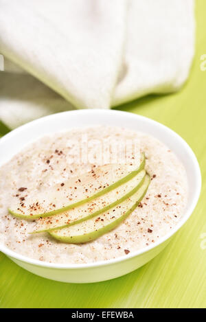 Porridge di fiocchi d'avena con mele e cannella in ciotola bianco Foto Stock