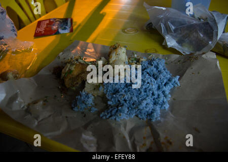 Tradizionale cibo malese. Nasi kerabu è un tipo di nasi ulam, popolare Malay piatto di riso. Colore blu del riso. Foto Stock