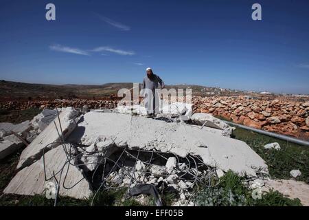 Nablus, West Bank, Territorio palestinese. 2° febbraio 2015. Un uomo palestinese ispeziona la sua proprietà, dopo i bulldozer israeliano demolito, nel villaggio di Qusra sud della Cisgiordania città di Nablus. Testimoni detto i militari israeliani hanno distrutto due camere agricole e un pozzo di mancare di permessi di costruzione. Israele ha distrutto 590 edifici palestinese in Cisgiordania, compresa Gerusalemme Est, nel 2014, spostando 1.177 persone, secondo un nuovo studio dell'Ufficio delle Nazioni Unite per il Coordinamento degli Affari Umanitari (OCHA). Questo costituisce il più alto livello di spostamento nella West Bank poiché la U Foto Stock