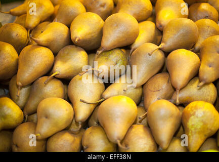 Appena raccolto le pere in fila sul mercato degli agricoltori. Un mucchio di golden brown pere close up Foto Stock