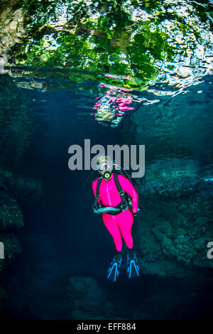 Femmina sub esplorare grotte sottomarine Foto Stock