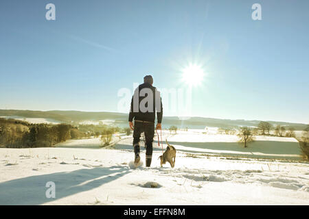 Germania, Bergisches Land, man walking cane nel paesaggio invernale Foto Stock