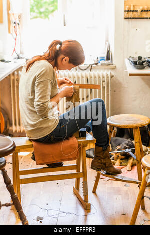 Donna cucito in oggetti di selleria seduta sul pony di legatura Foto Stock