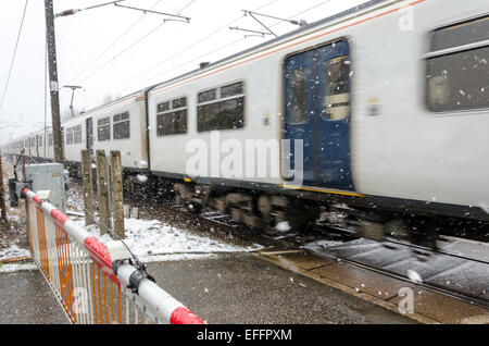 Sawston, Cambridge, UK. 3 febbraio 2015. Regno Unito Meteo: un treno in direzione nord sulla Londra Liverpool Street a Cambridge la linea viaggia attraverso la neve in corrispondenza di un passaggio a livello Sawston. Credito: David Jackson/Alamy Live News Foto Stock