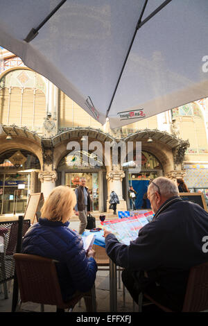 Due turisti studiare una mappa turistica al di fuori del mercato centrale di Valencia Foto Stock