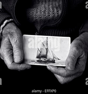 Pescatore con una vecchia fotografia di una nave a vela, chiudere fino in bianco e nero Foto Stock