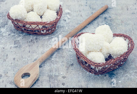 Disposizione dei cookie di cocco su marrone cesti e cucchiaio di legno Foto Stock