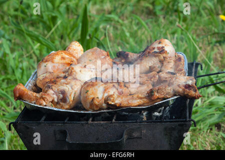 Grigliata di cosce di pollo sulla griglia fiammeggianti. Foto Stock
