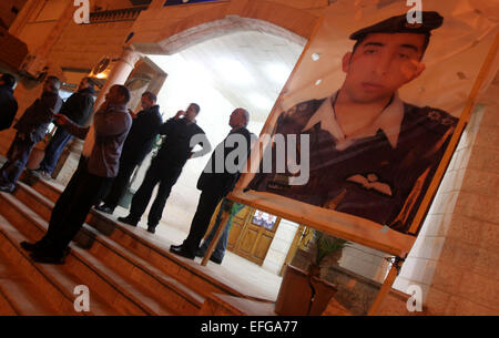 Amman, Giordania. 3 febbraio, 2015. Persone in stand by un poster del Giordano Moaz pilota al-Kasasbeh dopo il rilascio di un video che si asseriscono che mostra uno stato islamico captive Giordani essendo pilota bruciato vivo nel pilota della città natale Karak, Giordania, nel febbraio 3, 2015. Governo giordano martedì ha confermato l uccisione del pilota di giordani tenuto prigioniero da uno Stato islamico (SI), secondo membro-run Petra nuova agenzia. Credito: Mohammad Abu Ghosh/Xinhua/Alamy Live News Foto Stock