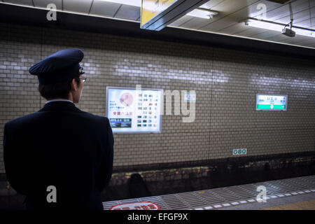 Stazione ufficiale di equipaggio in attesa del treno alla stazione di Hibiya, Tokyo, Giappone Foto Stock