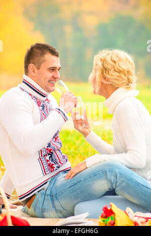 Il marito e la moglie di bere champagne da occhiali nel parco Foto Stock