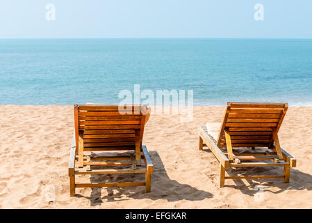 Coppia di sedie vuote su di una spiaggia di sabbia nel pomeriggio Foto Stock
