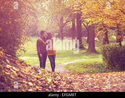 Amore giovane a piedi nella pittoresca foresta di autunno Foto Stock