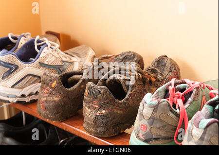 Wet fangoso running Scarpe rivestite di fango da cross country la formazione che mostra i dettagli di lacci e materiale traspirante Foto Stock