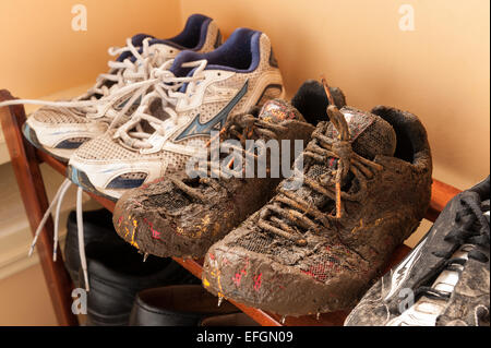 Wet fangoso running Scarpe rivestite di fango da cross country la formazione che mostra i dettagli di lacci e materiale traspirante Foto Stock