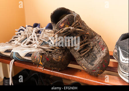 Wet fangoso running Scarpe rivestite di fango da cross country la formazione che mostra i dettagli di lacci e materiale traspirante Foto Stock