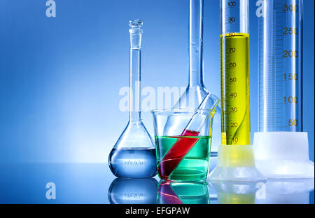 Attrezzature di laboratorio, bottiglie, flaconi con liquido a colori su sfondo blu Foto Stock