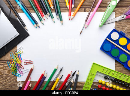 Scuola di telaio di cancelleria su sfondo di legno: carta, penna, pennello, forbici, cartelle, Abacus, Foto Stock