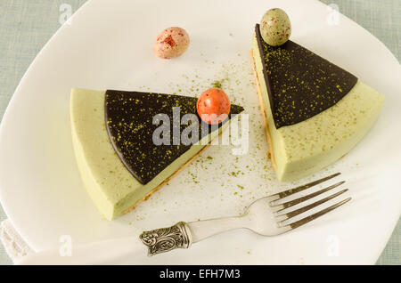 Torta di Pasqua con tè match decorate ganache al cioccolato e dolce-stuff uova. Vicino a tazza di caffè. A partire dalla serie elegante dessert Foto Stock