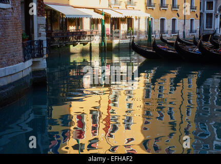 Gondole attraccate e riflessione della casa gialla Venezia Veneto Italia Europa Foto Stock