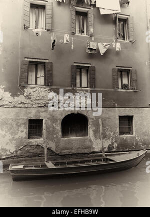 Scena veneziana con lavaggio appendere fuori e barca ormeggiata su canal Venezia Veneto Italia Europa Foto Stock