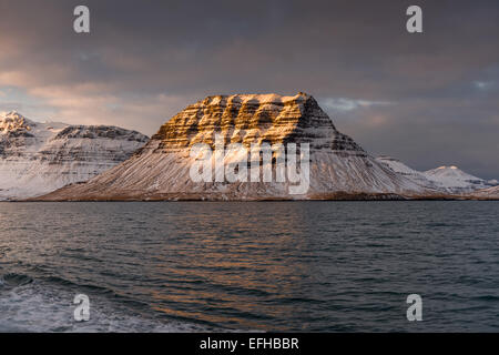 Islandese di alba e Grundarfjorour Kirkjufell, preso a bordo di una nave sul mare vicino al piccolo villaggio di pescatori di Grundarfjordur Foto Stock