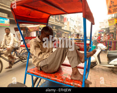 L'uomo addormentato in rickshaw in India Foto Stock