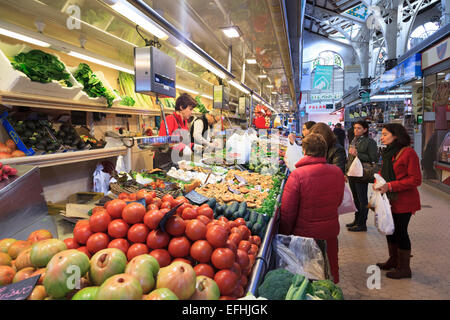 I clienti che acquistano prodotti a frutta e verdura in stallo il mercato centrale di Valencia Foto Stock