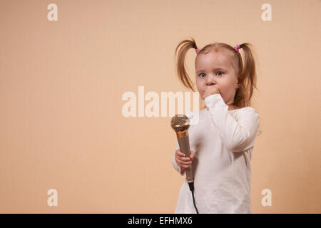 Bambina tenendo il microfono Foto Stock