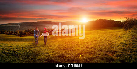 Amare giovane holding hands in esecuzione sul campo. bellissimo paesaggio Foto Stock