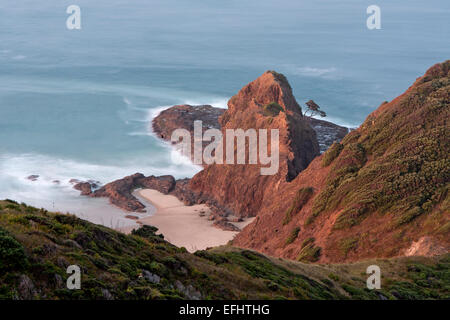 Cape Reinga, sacro luogo Maori dove gli spiriti dei morti immettere la malavita, riunione dell'Oceano Pacifico e il Mare di Tasmania, Te Foto Stock