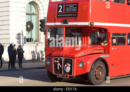 London Double Decker bus con pupazzo di neve e candy cane le decorazioni di Natale sulla parte anteriore Foto Stock