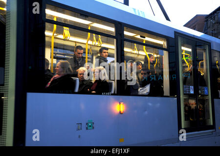 Manchester Lancashire Regno Unito - pendolari su un centro città in tram di notte guardando fuori della finestra di Gennaio 2015 Foto Stock