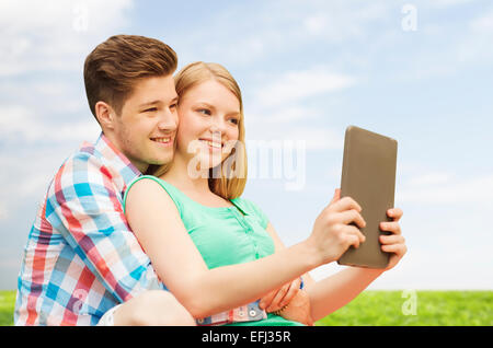 Coppia felice con i tablet pc tenendo selfie all'aperto Foto Stock