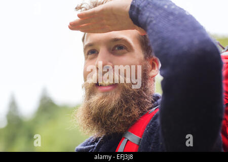 Uomo sorridente con la barba e zaino escursionismo Foto Stock