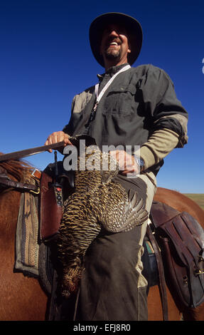 Un cacciatore a cavallo con una prateria di pollo mentre la caccia in Sud Dakota Foto Stock