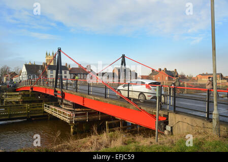 Il traffico che attraversa selby ponte girevole sul fiume Ouse con selby abbey nella distanza Yorkshire Regno Unito Foto Stock