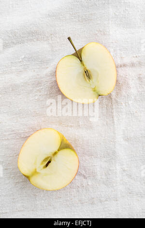 Due metà di Apple su una tovaglia di lino Foto Stock