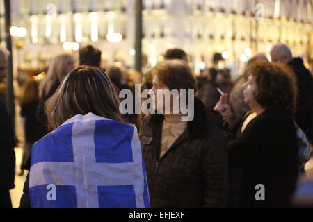 Atene, Grecia. 5 febbraio 2015. Una donna è avvolto in una bandiera greca. Migliaia di Greci assemblati a piazza Syntagma, per protestare contro il regime fiscale di estorsione da parte della Troika che vuole che la Grecia a seguire le loro istruzioni in ritorno per fornire il denaro necessario per le banche greche. Credito: Michael Debets/Alamy Live News Foto Stock