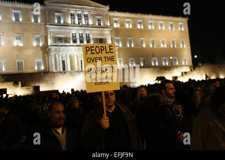 Atene, Grecia. 5 febbraio 2015. Un uomo può contenere fino un poster a leggere 'persone oltre i mercati - dobbiamo cambiare l'Europa". Migliaia di Greci assemblati a piazza Syntagma, per protestare contro il regime fiscale di estorsione da parte della Troika che vuole che la Grecia a seguire le loro istruzioni in ritorno per fornire il denaro necessario per le banche greche. Credito: Michael Debets/Alamy Live News Foto Stock