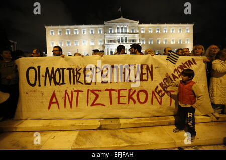 Atene, Grecia. 5 febbraio 2015. Manifestanti stand con un banner al di fuori del parlamento greco. Migliaia di Greci assemblati a piazza Syntagma, per protestare contro il regime fiscale di estorsione da parte della Troika che vuole che la Grecia a seguire le loro istruzioni in ritorno per fornire il denaro necessario per le banche greche. Credito: Michael Debets/Alamy Live News Foto Stock