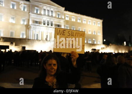 Atene, Grecia. 5 febbraio 2015. Una donna può contenere fino un poster di lettura "condividiamo il nostro governo". Migliaia di Greci assemblati a piazza Syntagma, per protestare contro il regime fiscale di estorsione da parte della Troika che vuole che la Grecia a seguire le loro istruzioni in ritorno per fornire il denaro necessario per le banche greche. Credito: Michael Debets/Alamy Live News Foto Stock