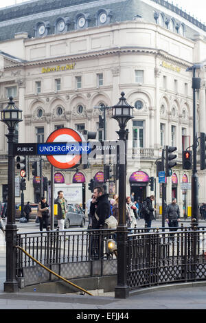 Segno della metropolitana e i turisti per le strade di Londra Inghilterra Foto Stock