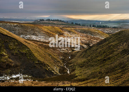 Nel tardo pomeriggio sole cade su Pendle Hill in Lancashire, Regno Unito, visto su una giornata invernale e dal vicino a Settle, North Yorkshire, al nord. Foto Stock