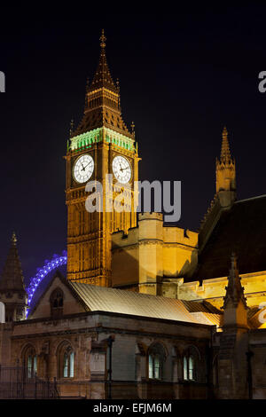 Il Palazzo di Westminster e il Big Ben con il London Eye sullo sfondo di notte, Londra, Inghilterra Foto Stock