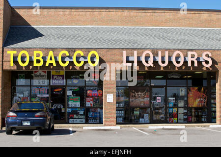 Il tabacco e il negozio di liquori segni con sola vettura parcheggiata di fronte Foto Stock