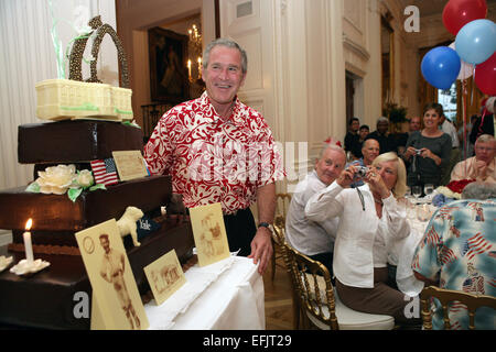 Il Presidente degli Stati Uniti George Bush che indossa una camicia hawaiana sorrisi come egli è presentato con una torta di compleanno durante una cena alla Casa Bianca il 4 luglio 2006 a Washington, DC. Bush si è festeggiato il suo sessantesimo compleanno. Foto Stock