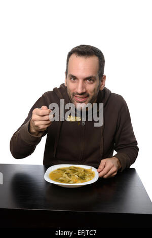 Giovane uomo di mangiare la minestra di verdura Foto Stock